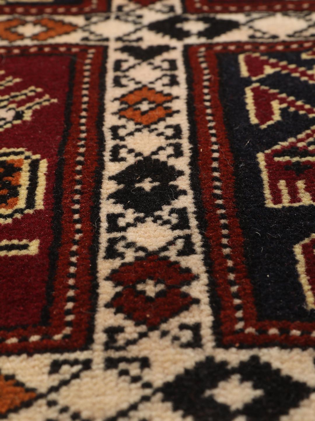 A hand-knotted Turkaman runner from the Middle East featuring a dark-red field with geometric motifs.
