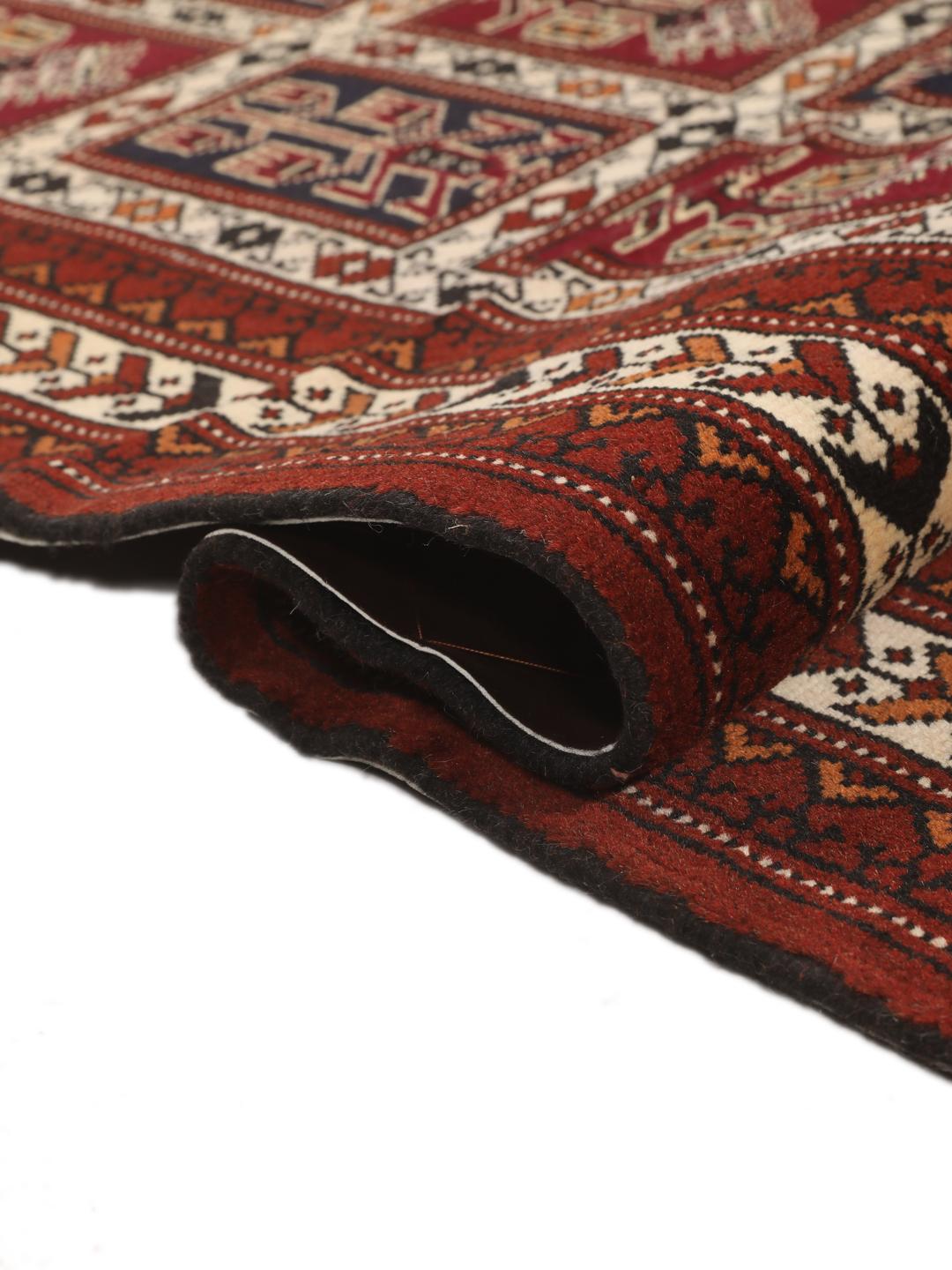 A hand-knotted Turkaman runner from the Middle East featuring a dark-red field with geometric motifs.