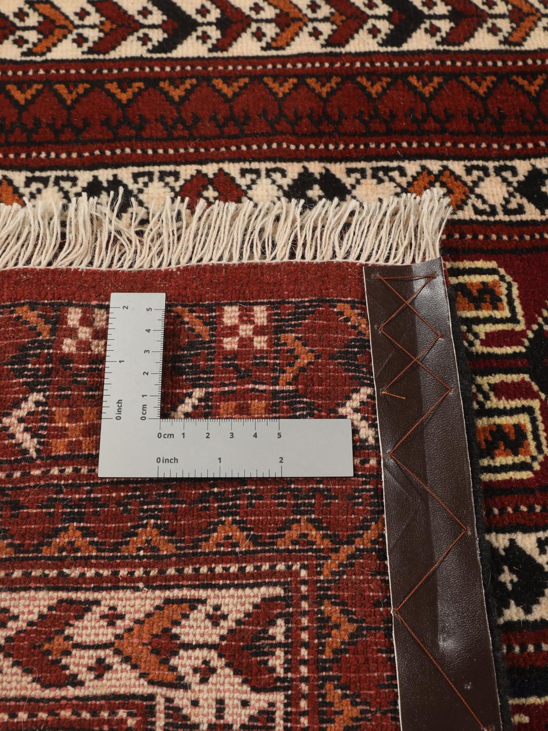 A hand-knotted Turkaman runner from the Middle East featuring a dark-red field with geometric motifs.