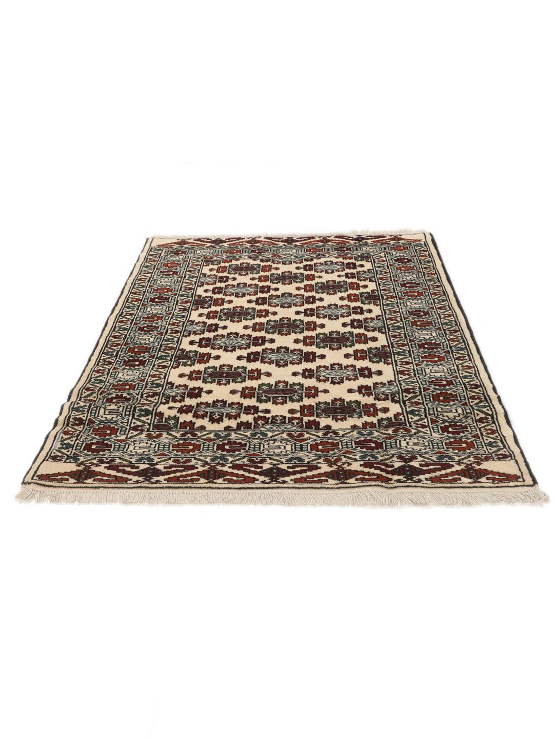Hand-knotted Turkaman rug from the Middle East with a beige background and traditional geometric motifs.