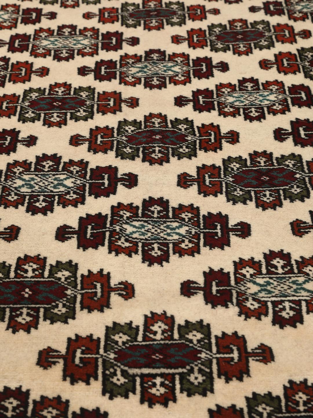Hand-knotted Turkaman rug from the Middle East with a beige background and traditional geometric motifs.