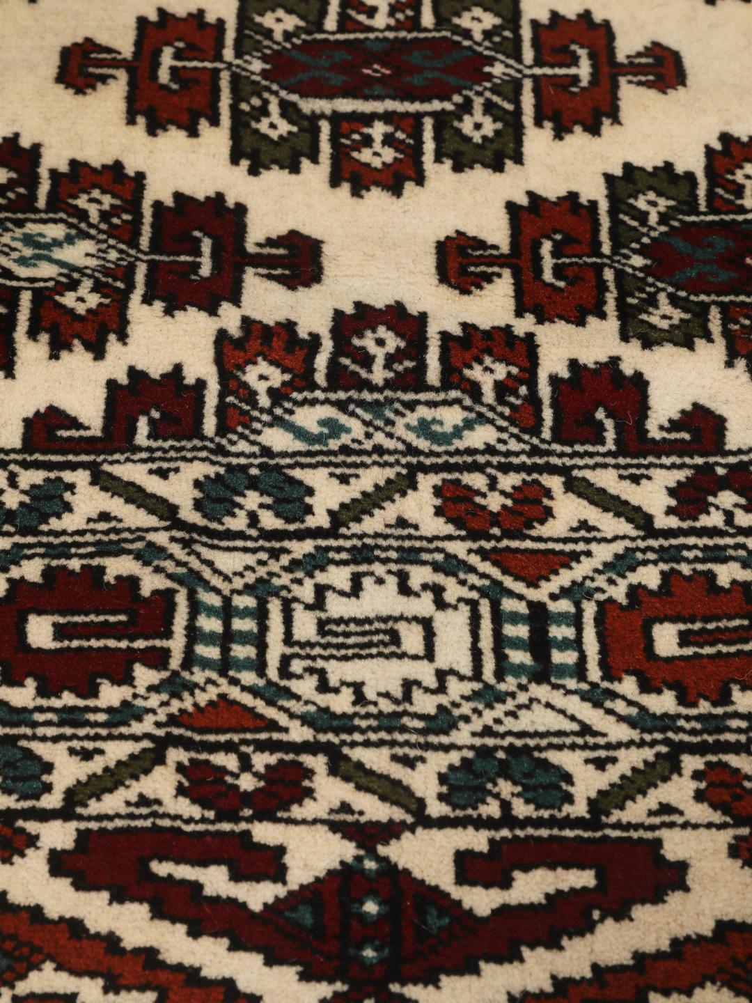 Hand-knotted Turkaman rug from the Middle East with a beige background and traditional geometric motifs.