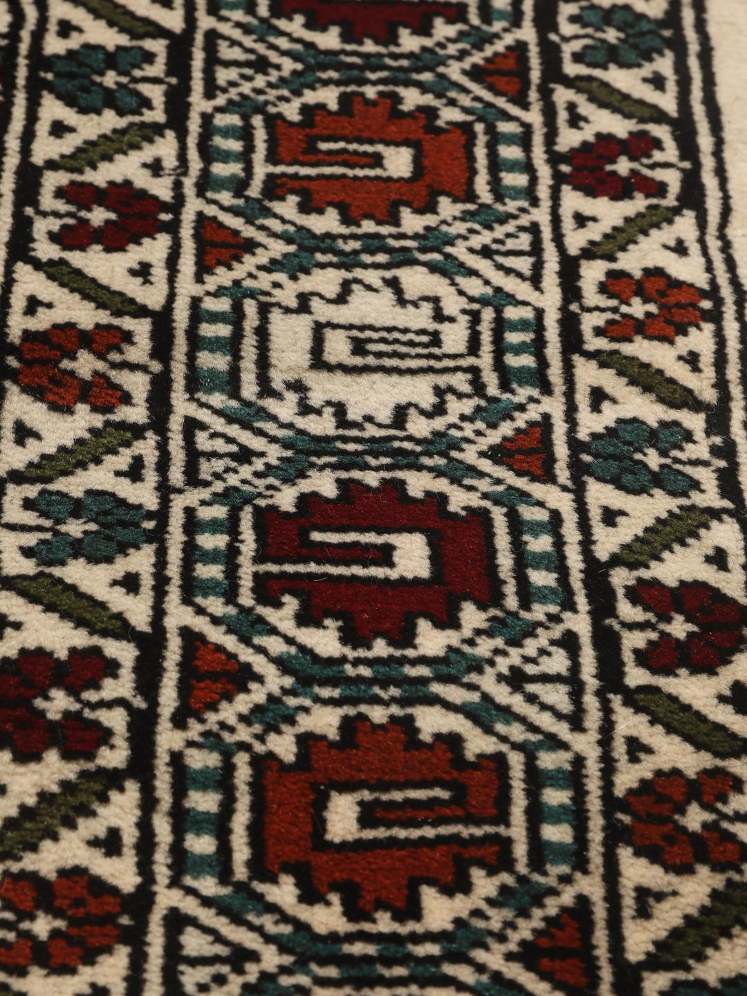 Hand-knotted Turkaman rug from the Middle East with a beige background and traditional geometric motifs.