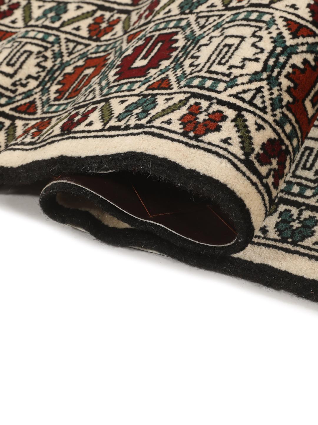 Hand-knotted Turkaman rug from the Middle East with a beige background and traditional geometric motifs.