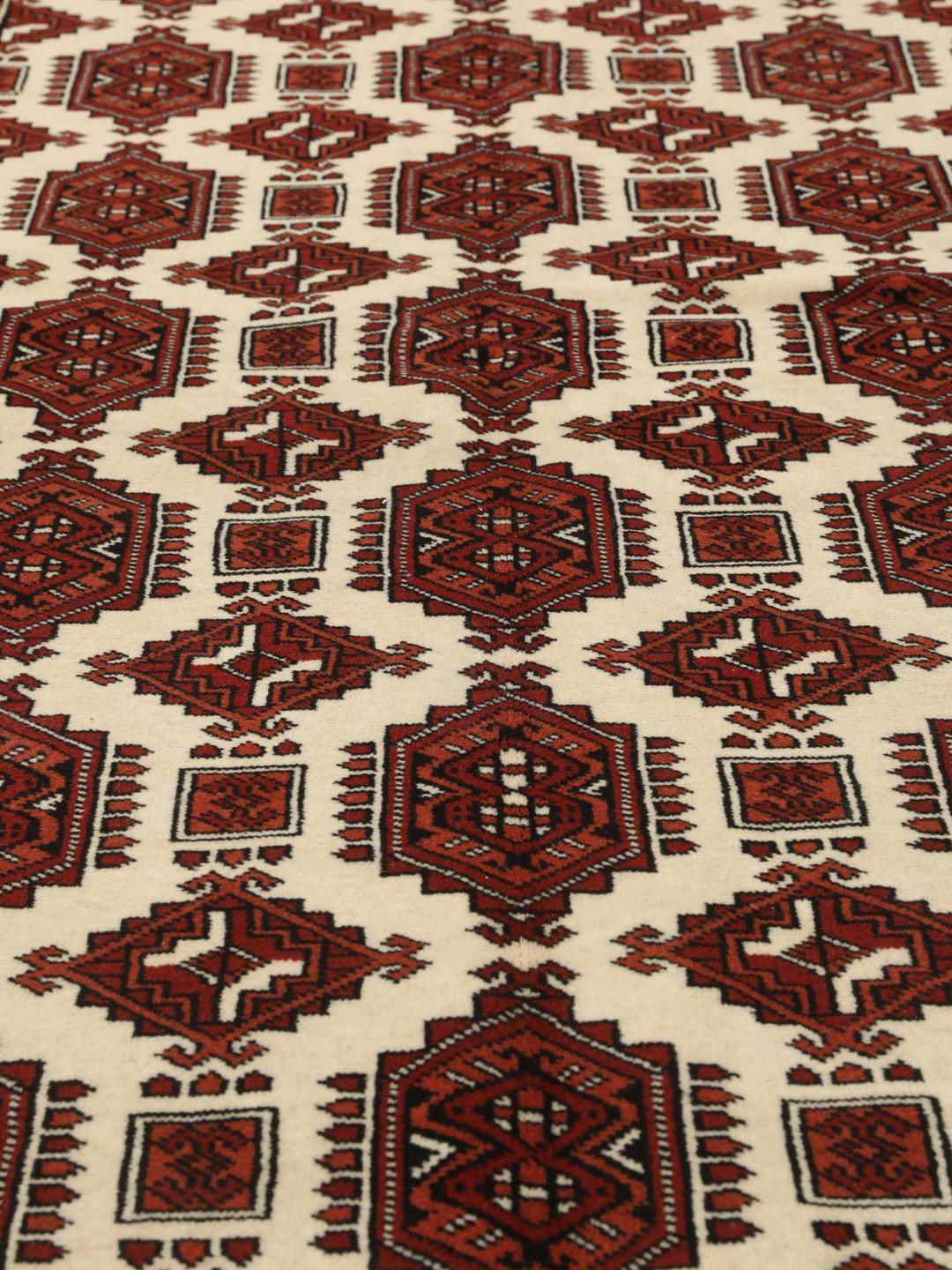 Hand-knotted Turkaman rug from the Middle East with a red and cream geometric design