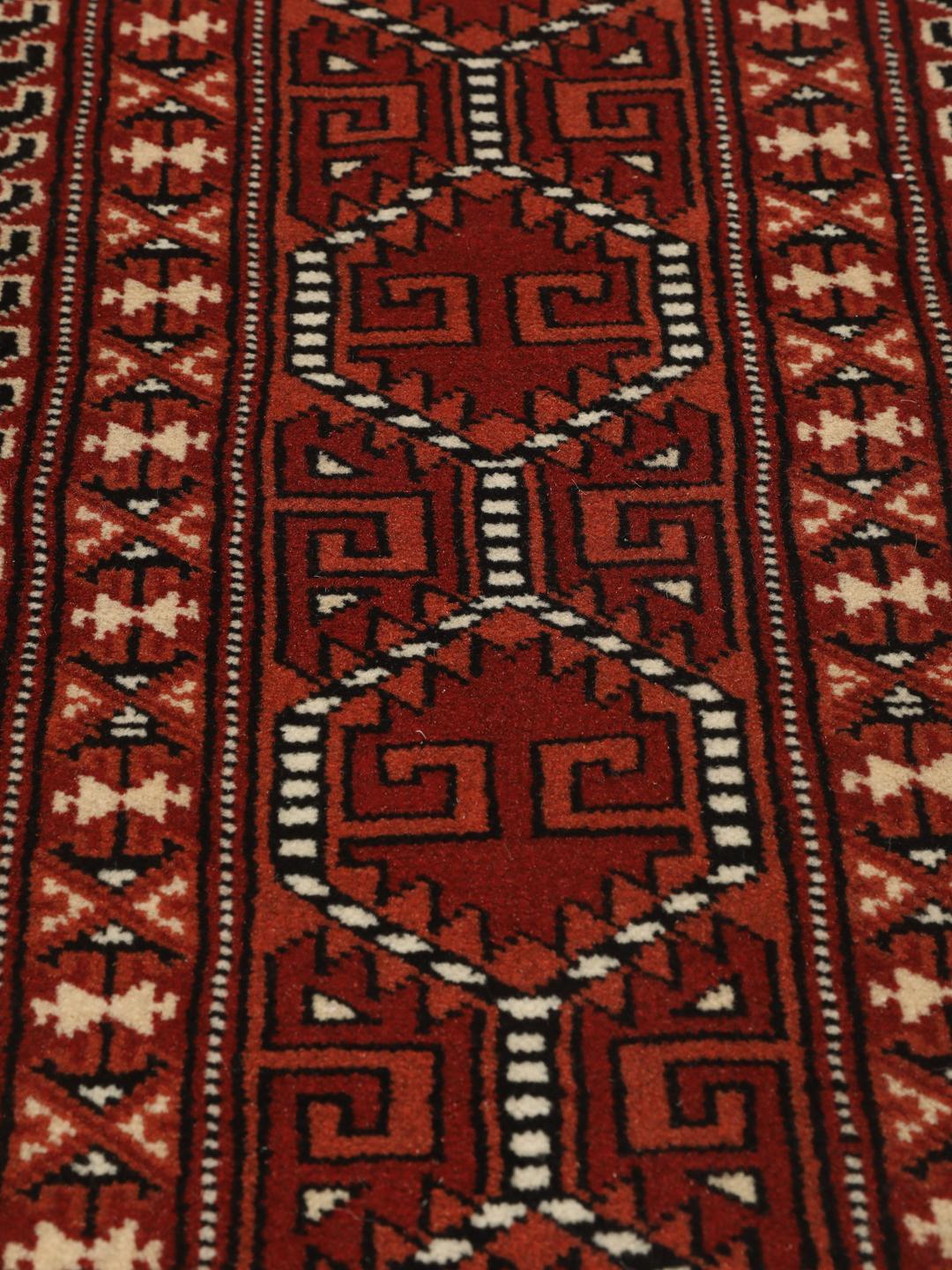 Hand-knotted Turkaman rug from the Middle East with a red and cream geometric design