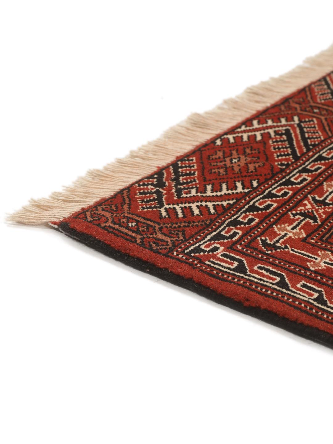 A hand-knotted Turkaman rug with a deep red field and traditional geometric motifs from the Middle East.