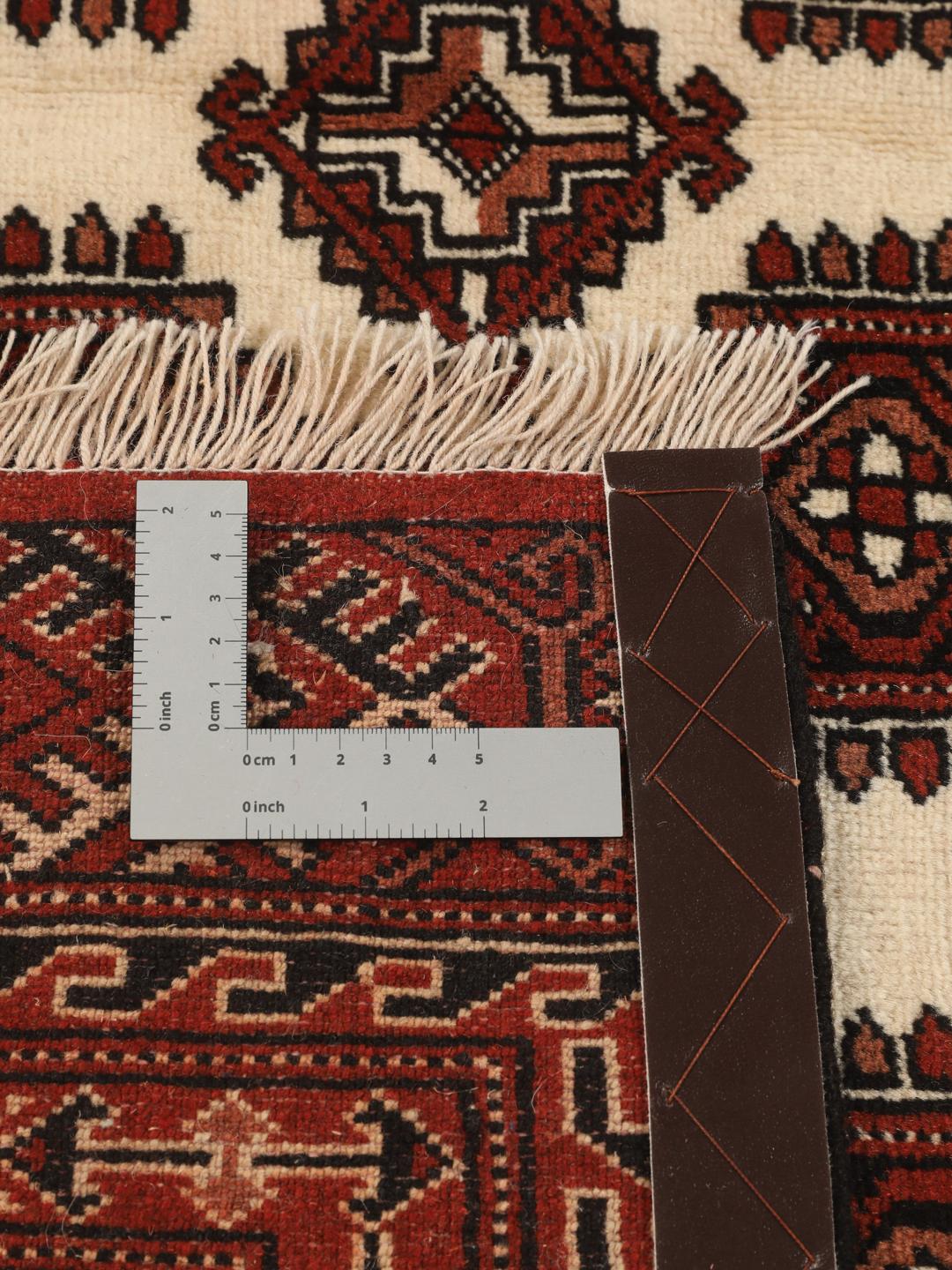 A hand-knotted Turkaman rug with a deep red field and traditional geometric motifs from the Middle East.