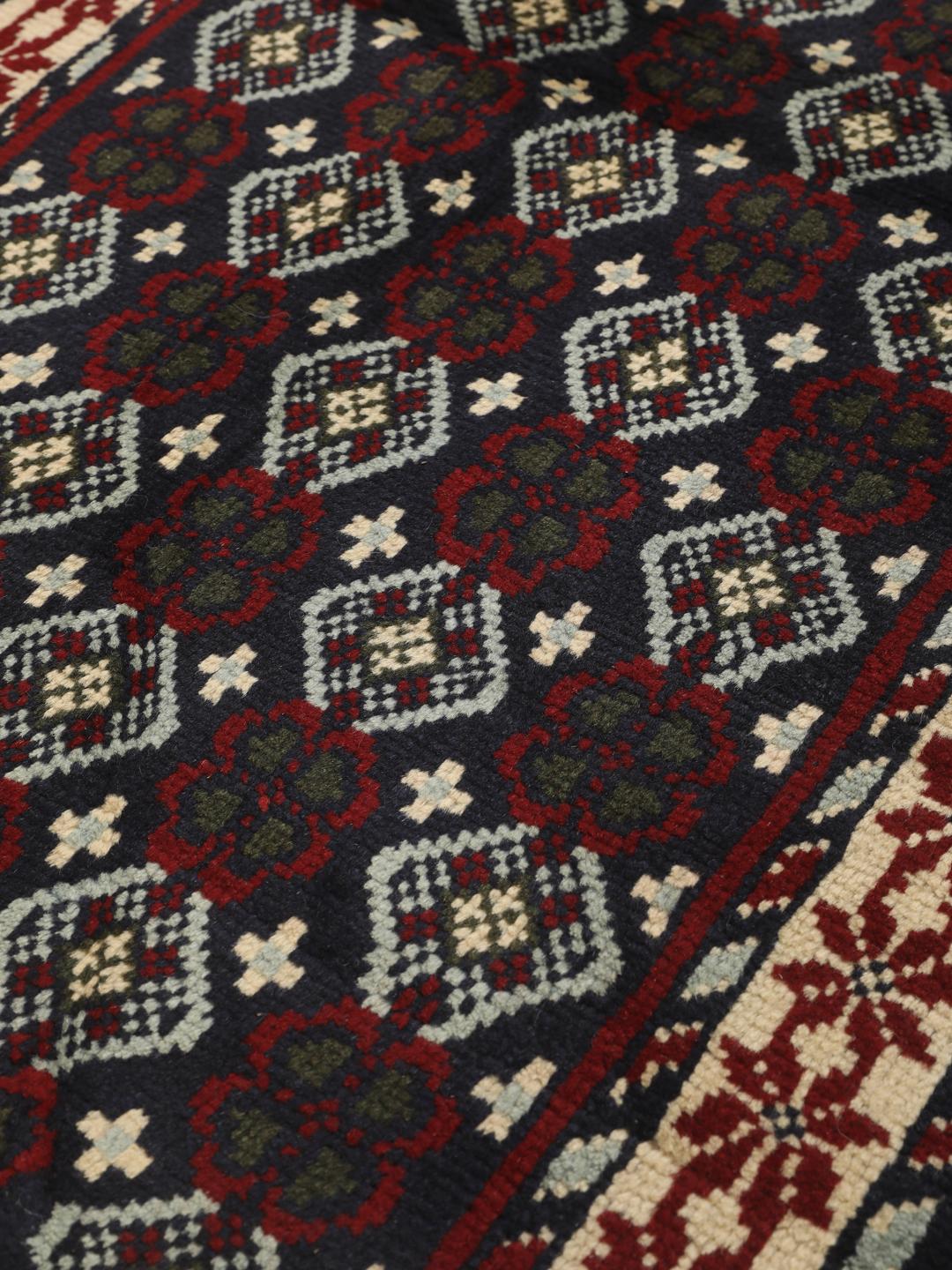 Handgeknoopt tapijt uit het Midden-Oosten met geometrische motieven in donkerblauw en rood