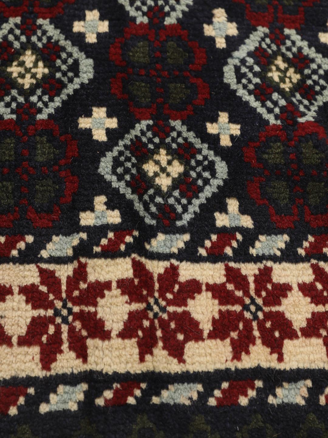 Handgeknoopt tapijt uit het Midden-Oosten met geometrische motieven in donkerblauw en rood