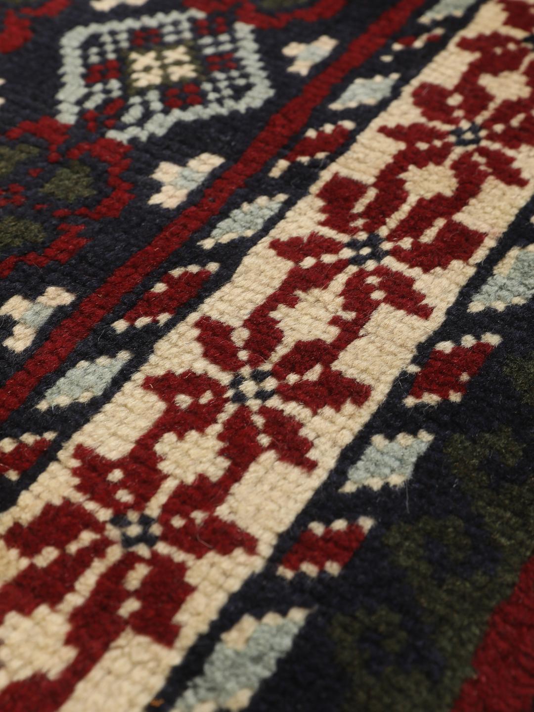 Handgeknoopt tapijt uit het Midden-Oosten met geometrische motieven in donkerblauw en rood
