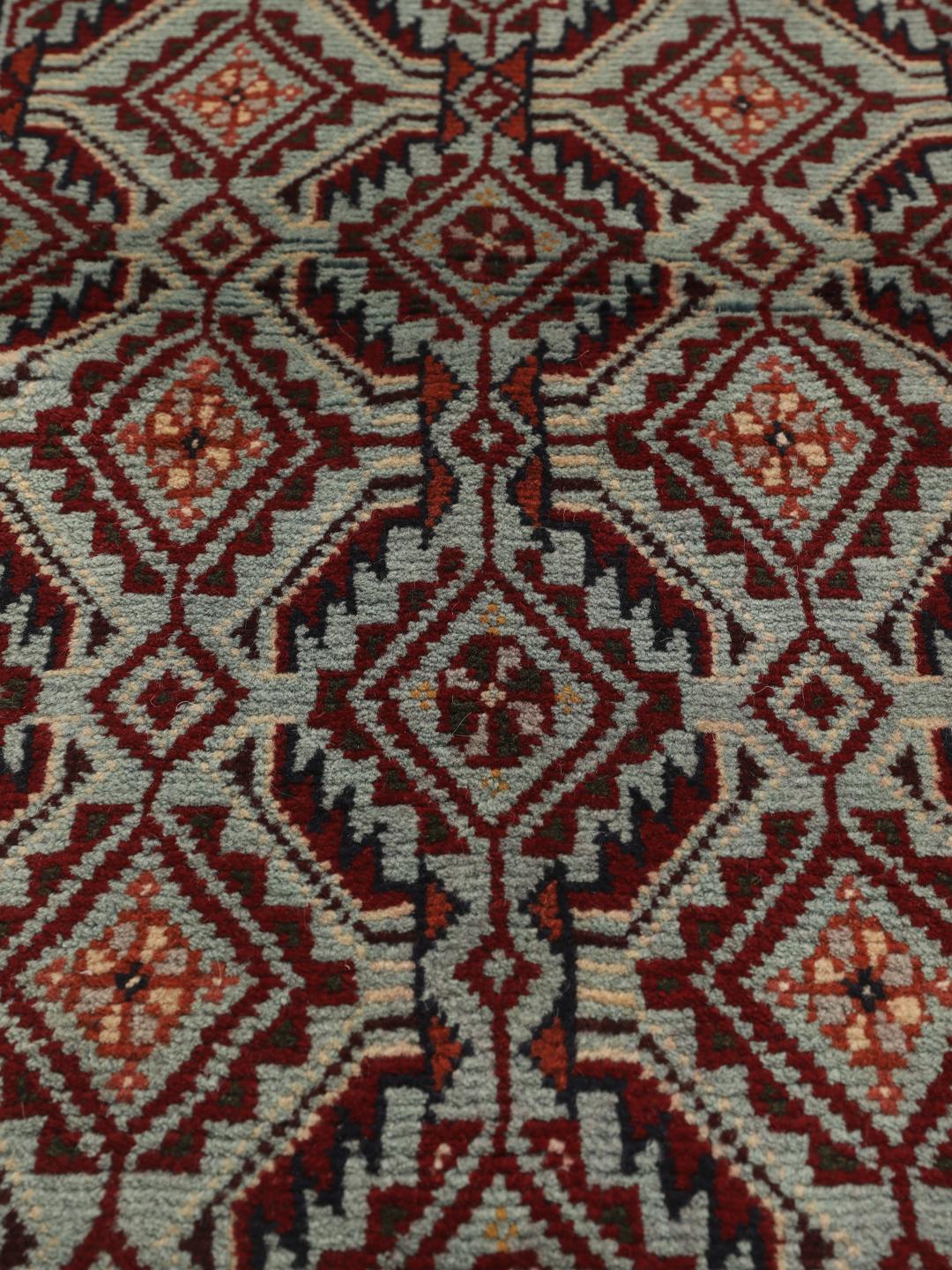 Hand-knotted Baluch rug with geometric motifs and red tones from the Middle East