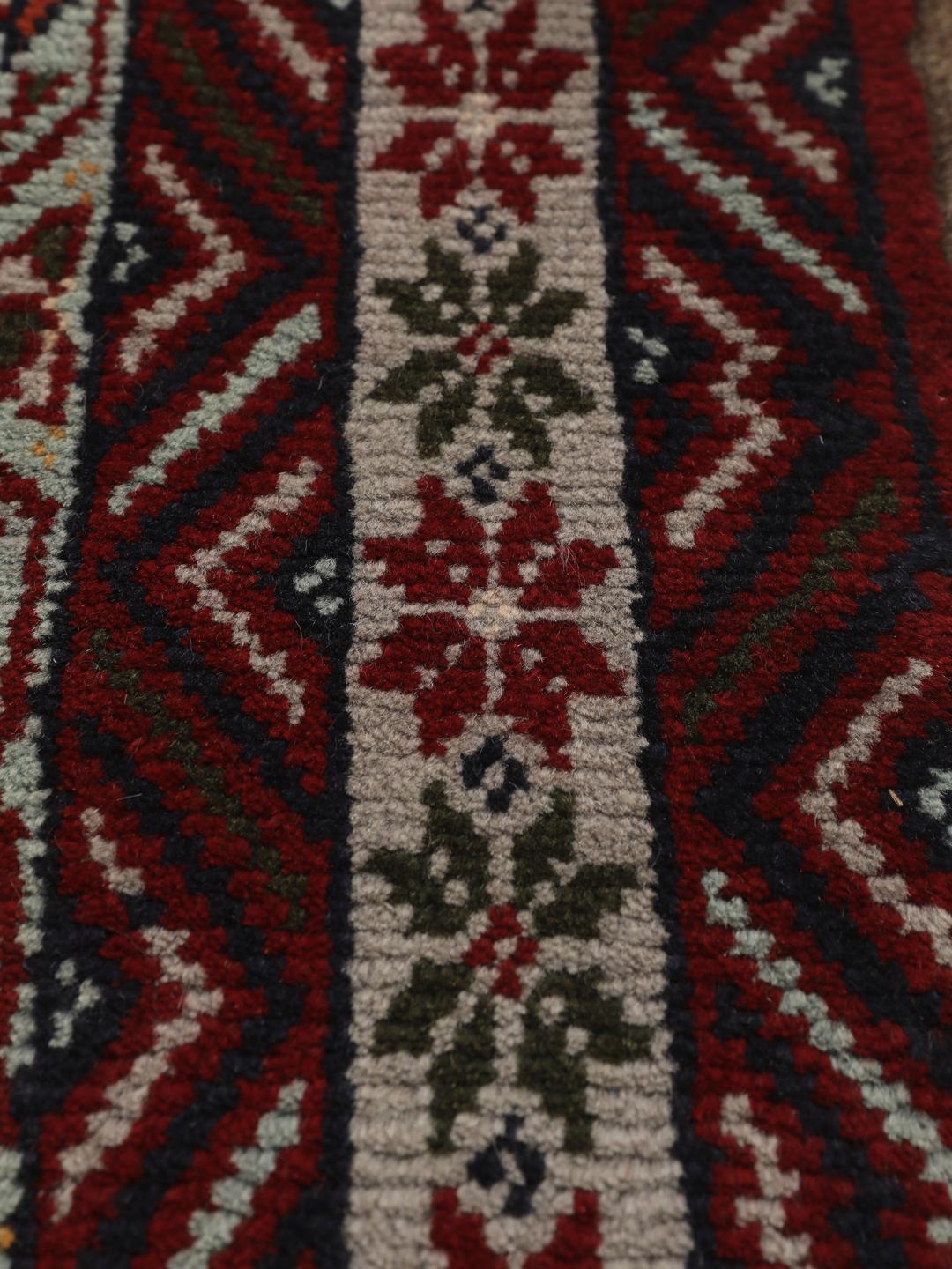 Hand-knotted Baluch rug with geometric motifs and red tones from the Middle East