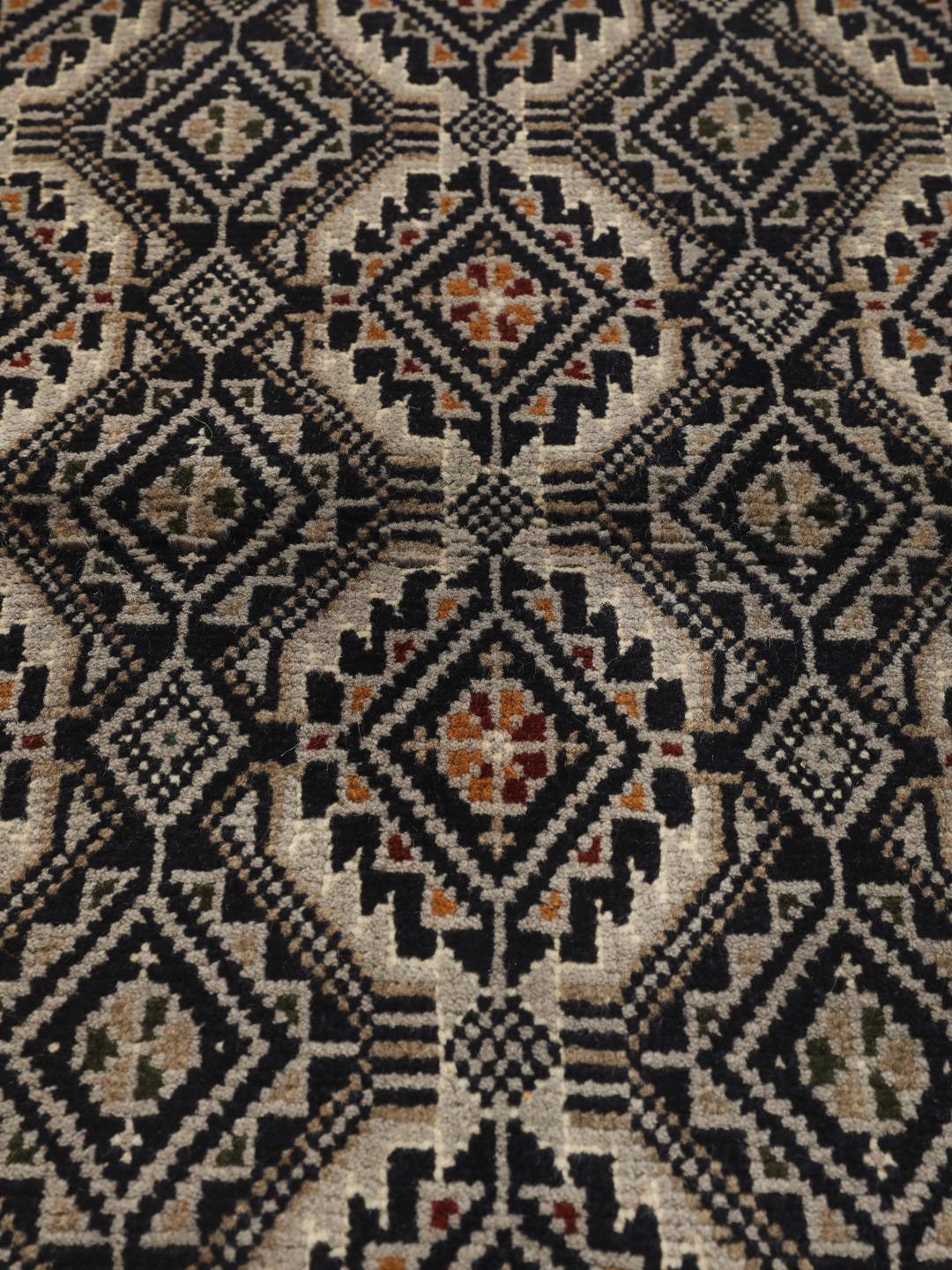 Hand-knotted Beluch rug from the Middle East in dark-blue and cream tones.