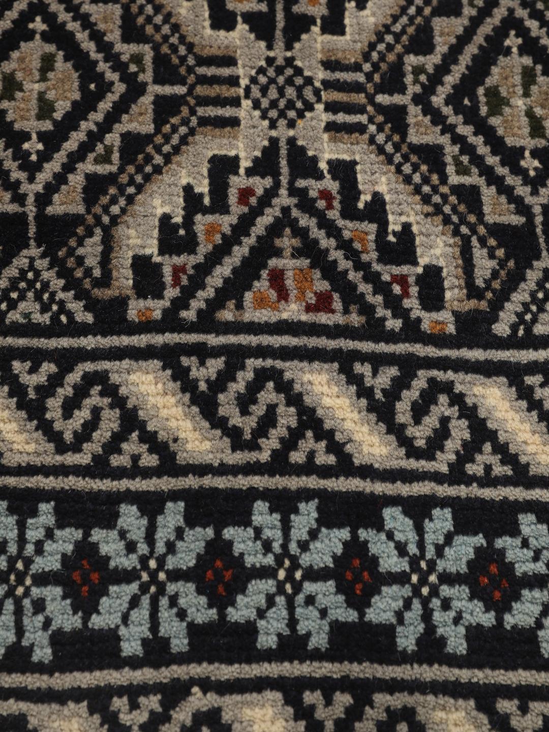 Hand-knotted Beluch rug from the Middle East in dark-blue and cream tones.