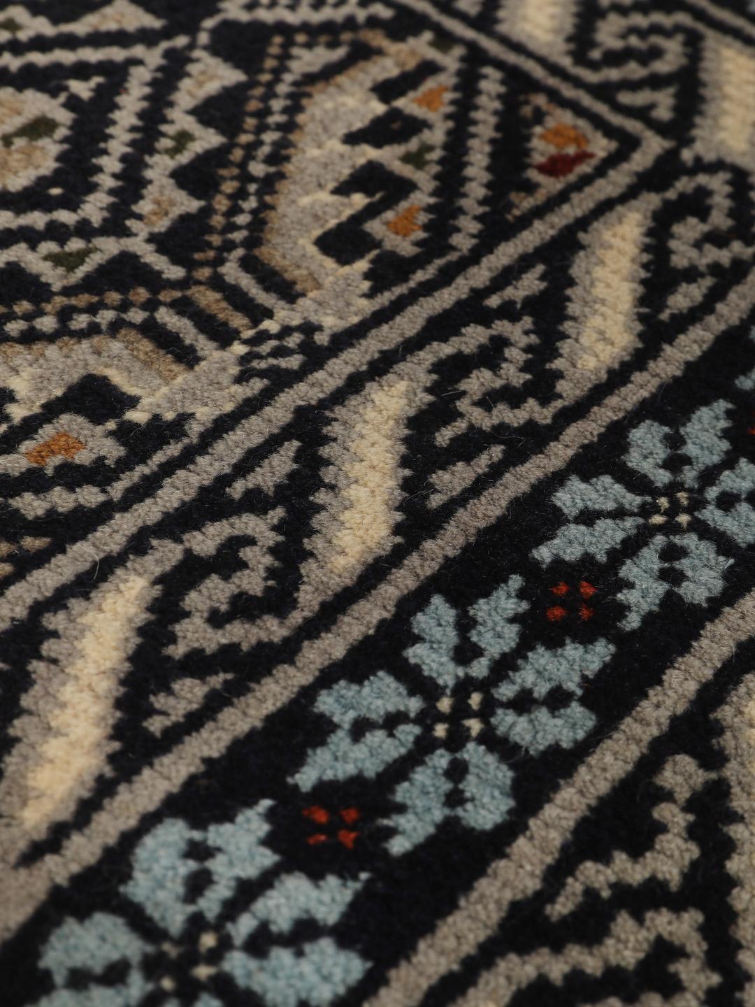 Hand-knotted Beluch rug from the Middle East in dark-blue and cream tones.