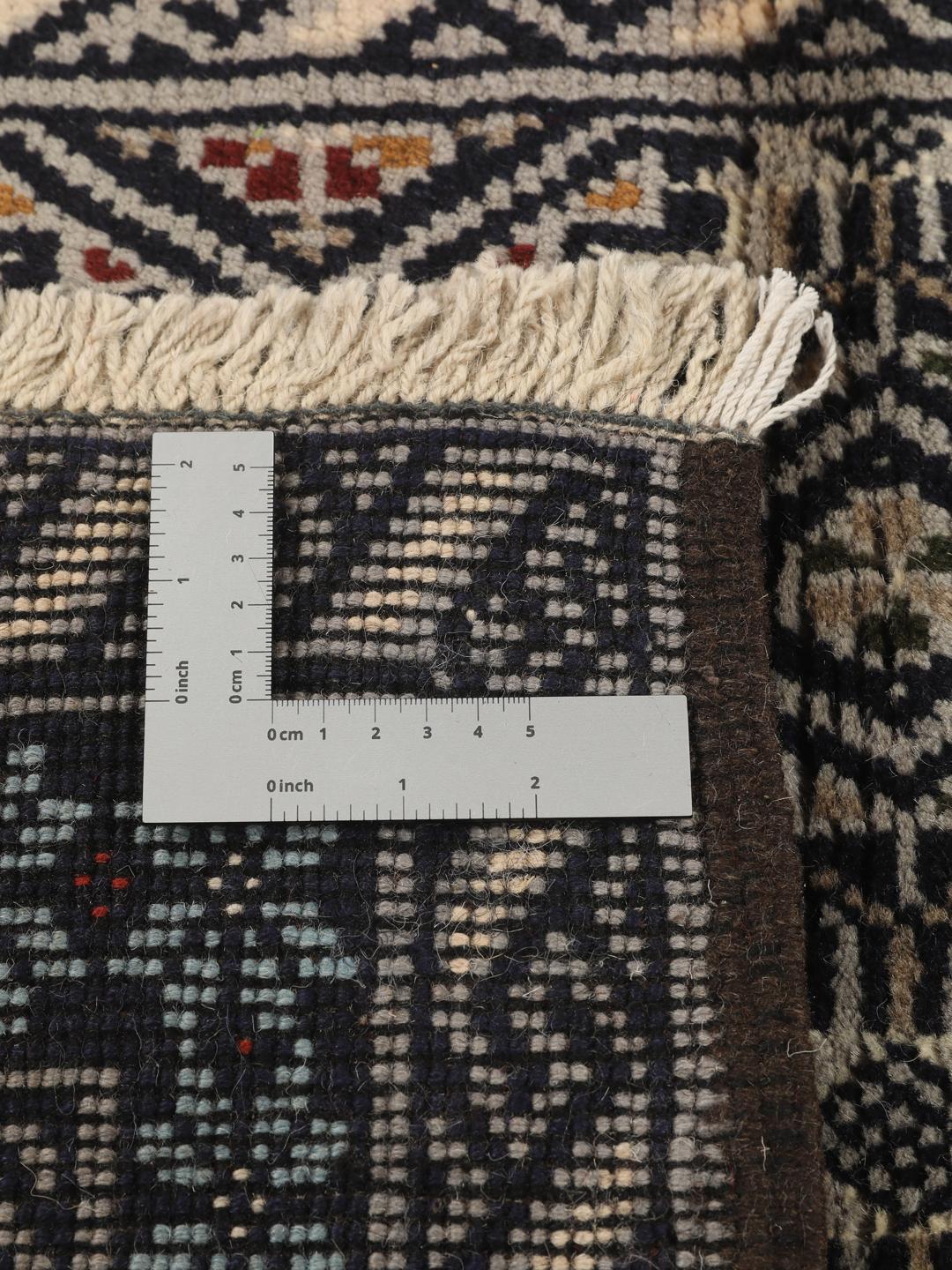 Hand-knotted Beluch rug from the Middle East in dark-blue and cream tones.