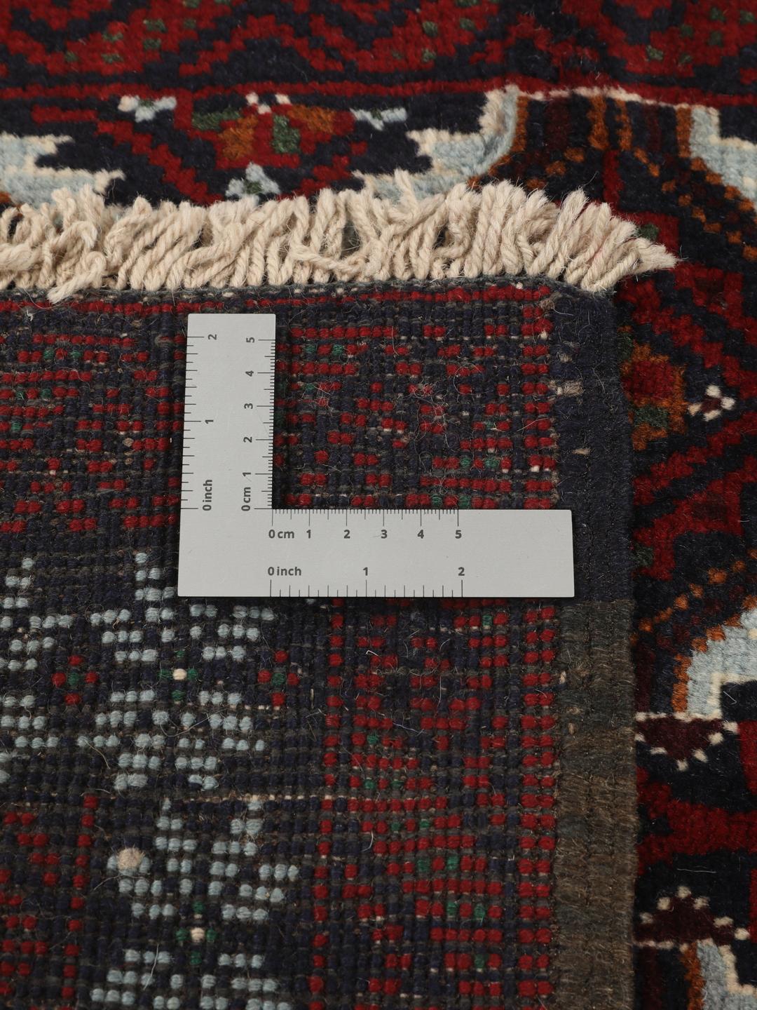 Håndknyttet Baluch-tæppe fra Mellemøsten med et mørkerødt og mørkeblåt mønster.