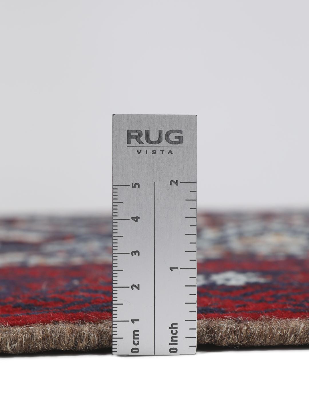 Hand-knotted Baluch rug with geometric motifs in dark-red and black tones.