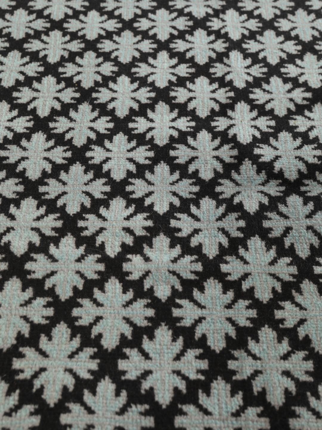 Handgeknoopt Baluch tapijt met geometrische motieven in zwart en lichtblauw, afkomstig uit het Midden-Oosten.