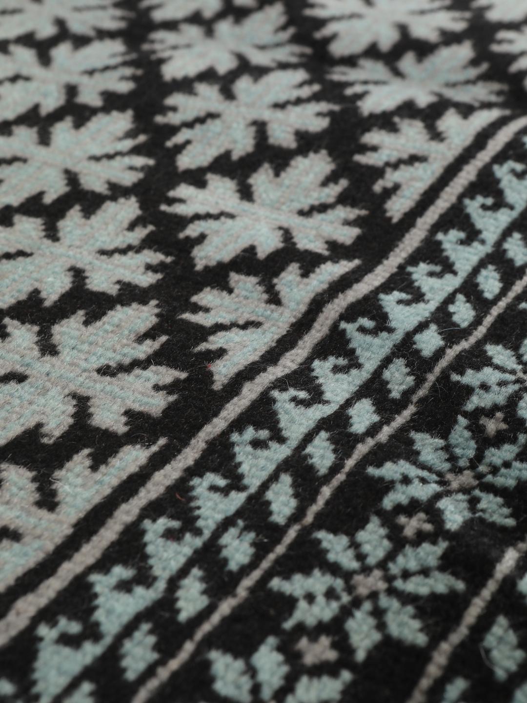 Handgeknoopt Baluch tapijt met geometrische motieven in zwart en lichtblauw, afkomstig uit het Midden-Oosten.