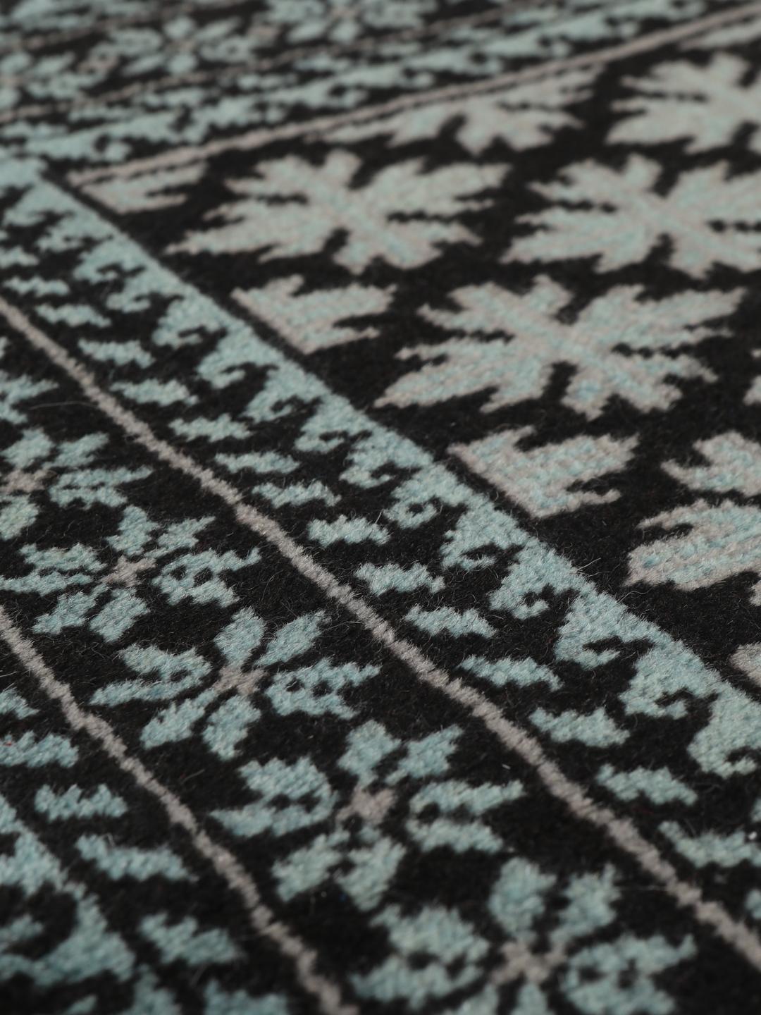 Handgeknoopt Baluch tapijt met geometrische motieven in zwart en lichtblauw, afkomstig uit het Midden-Oosten.