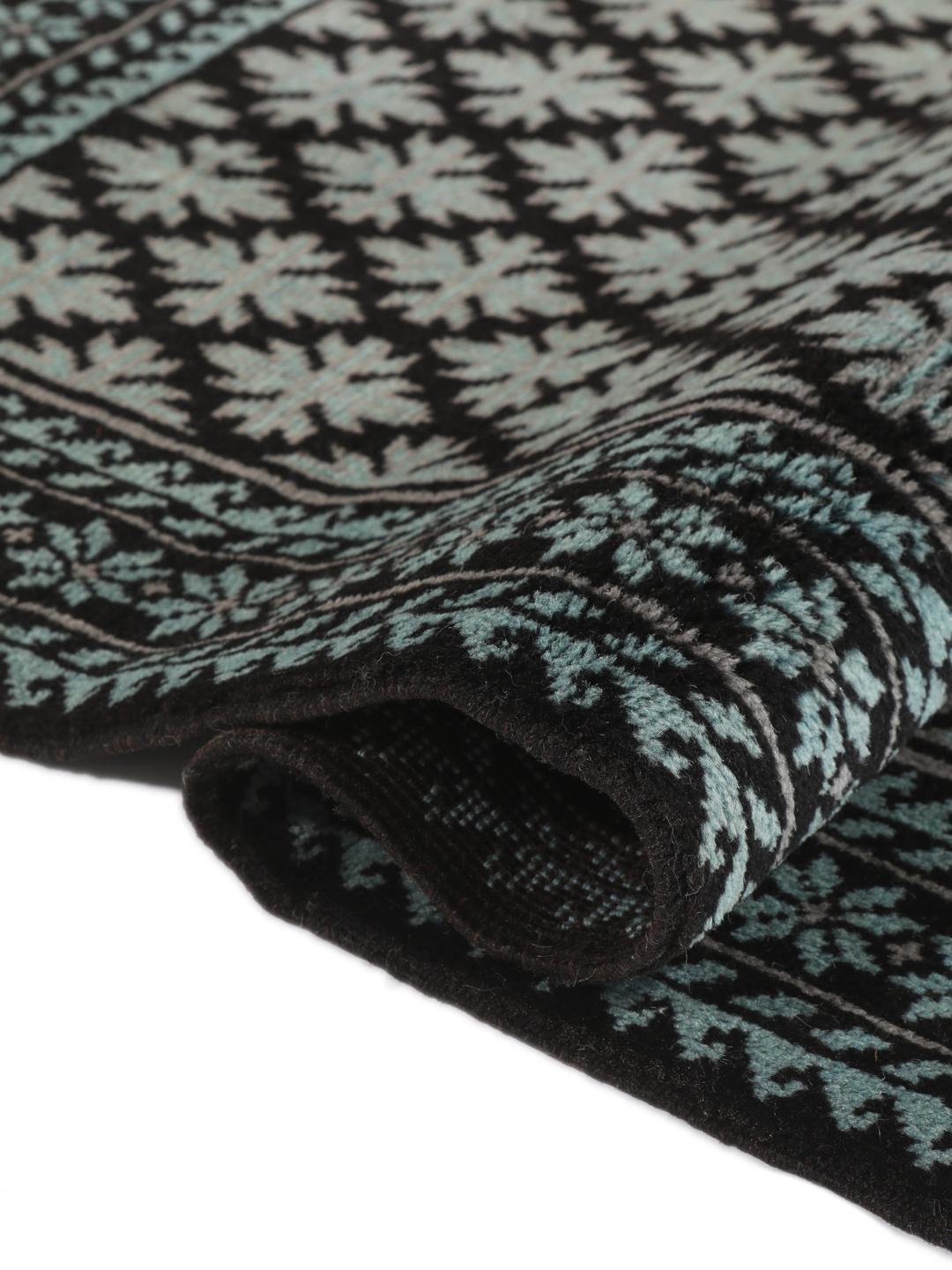 Handgeknoopt Baluch tapijt met geometrische motieven in zwart en lichtblauw, afkomstig uit het Midden-Oosten.