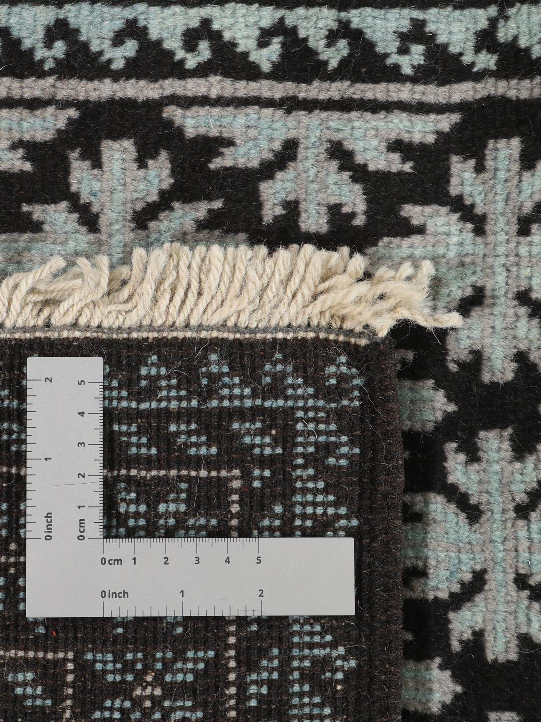 Handgeknoopt Baluch tapijt met geometrische motieven in zwart en lichtblauw, afkomstig uit het Midden-Oosten.
