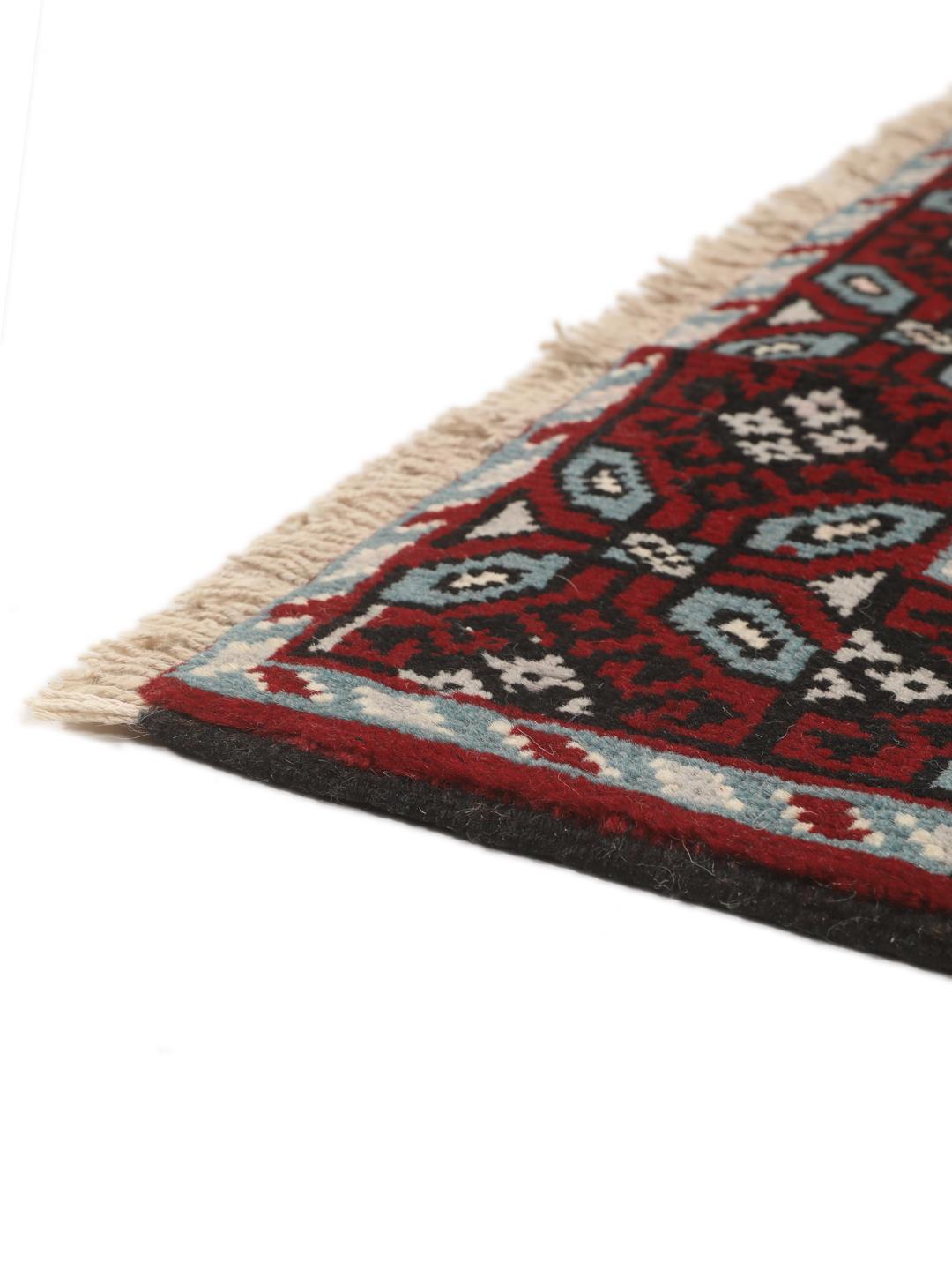 Handgeknoopt Baluch-tapijt uit het Midden-Oosten met een levendig rood en donker geometrisch patroon
