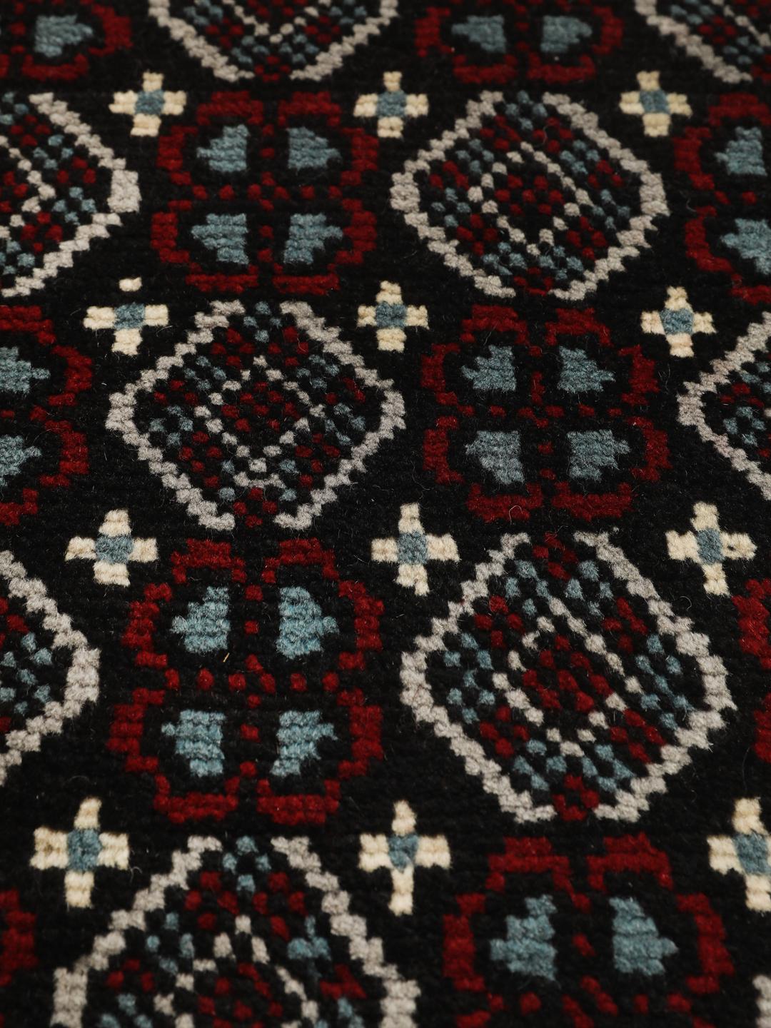 Handgeknoopt Baluch-tapijt uit het Midden-Oosten met een levendig rood en donker geometrisch patroon