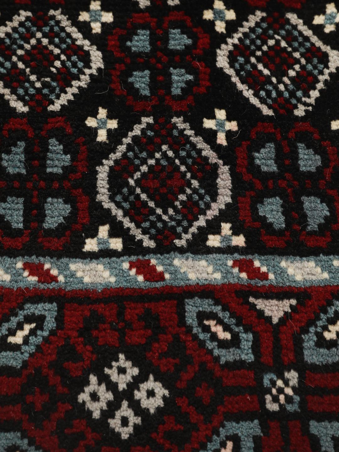 Handgeknoopt Baluch-tapijt uit het Midden-Oosten met een levendig rood en donker geometrisch patroon