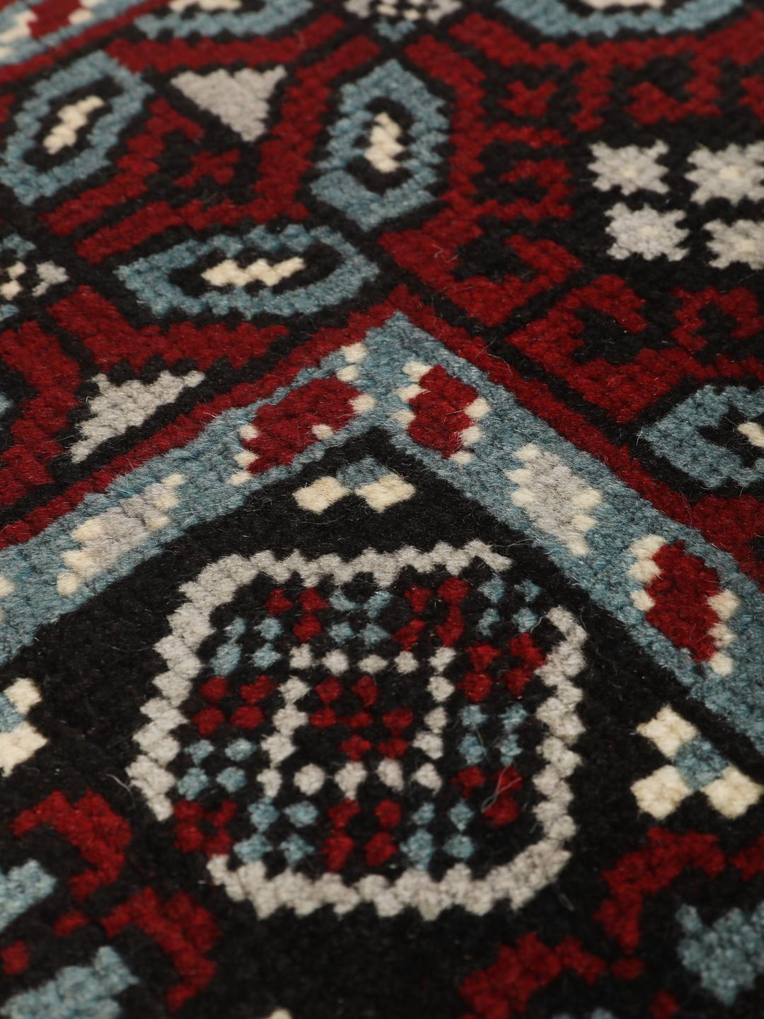 Handgeknoopt Baluch-tapijt uit het Midden-Oosten met een levendig rood en donker geometrisch patroon