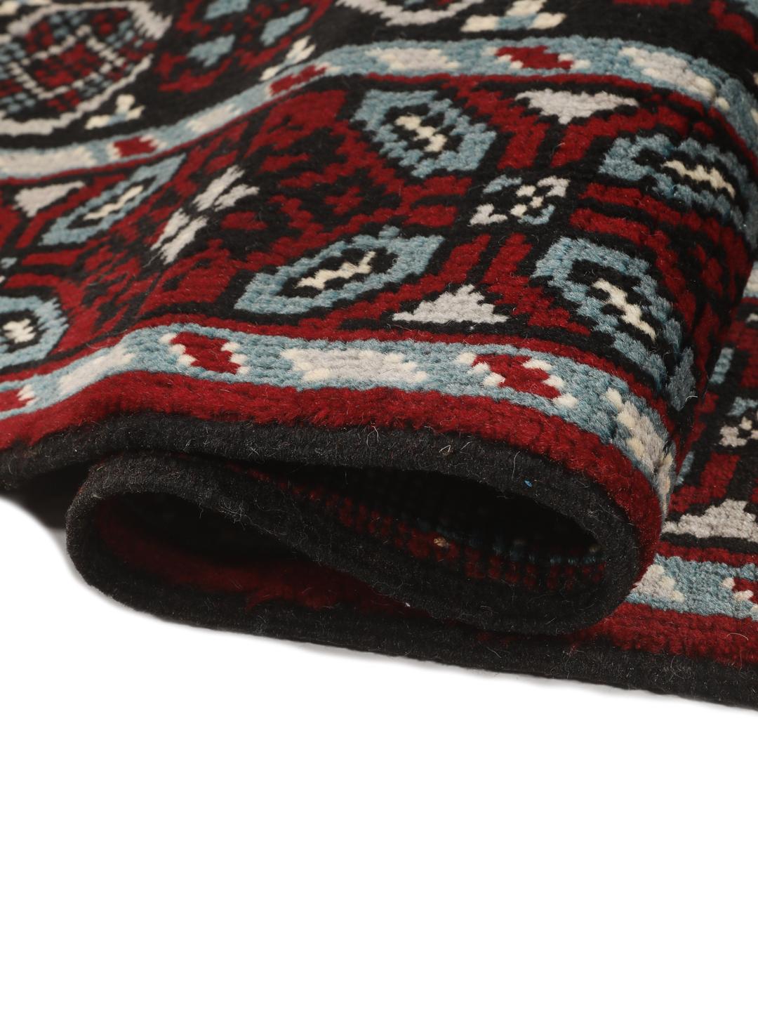Handgeknoopt Baluch-tapijt uit het Midden-Oosten met een levendig rood en donker geometrisch patroon