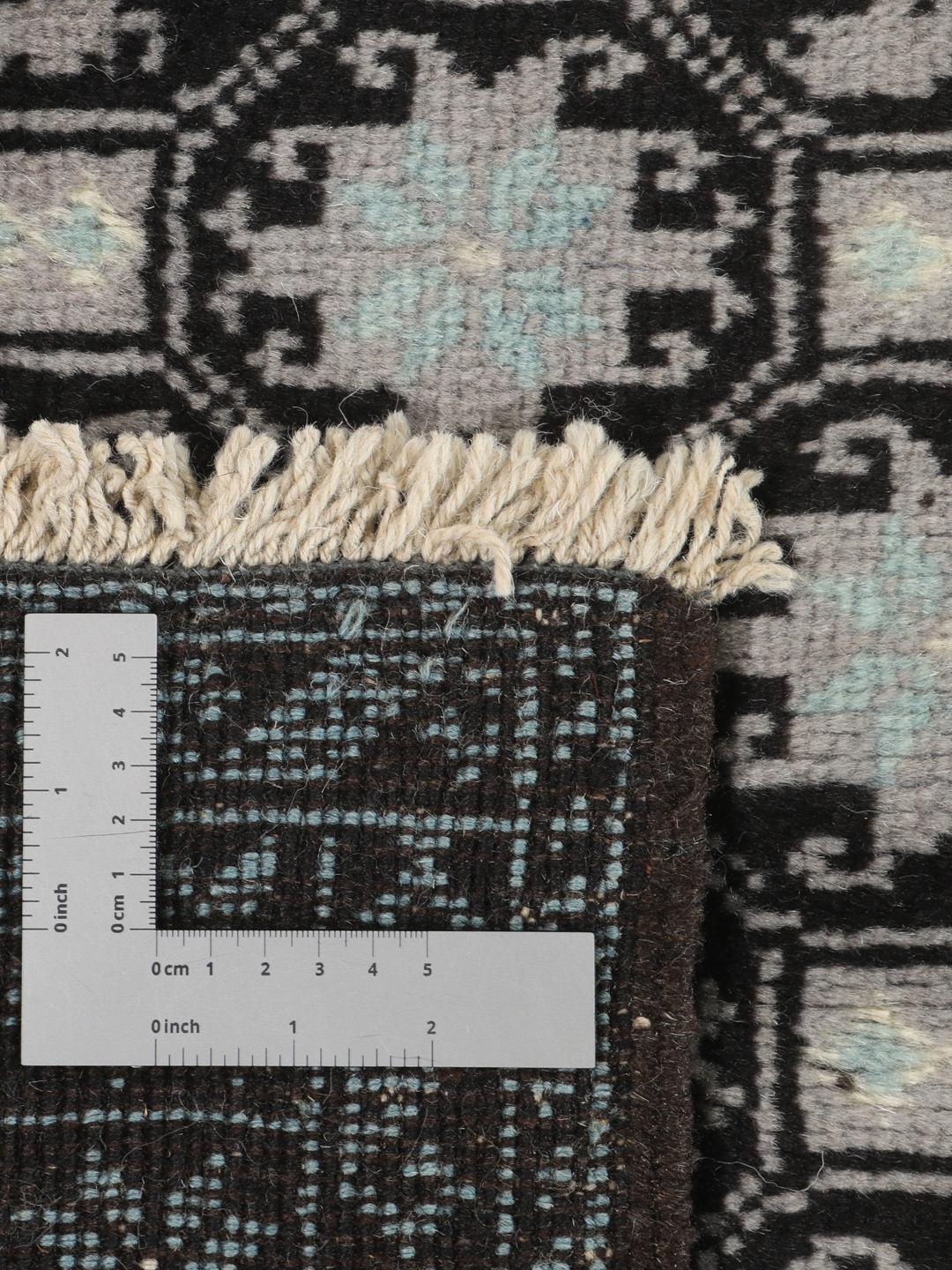 Håndknyttet Baluch-tæppe fra Mellemøsten med et sort og lyseblåt geometrisk design.