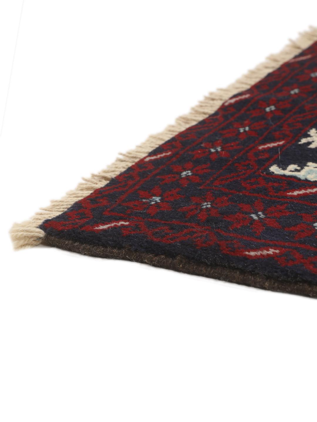 Handgeknoopt Baluch-tapijt met ingewikkelde geometrische motieven in donkerblauw en rood.
