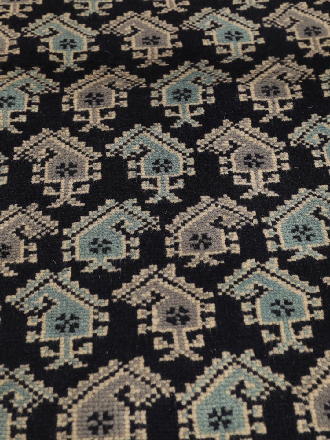 Handgeknoopt Baluch-tapijt met ingewikkelde geometrische motieven in donkerblauw en rood.