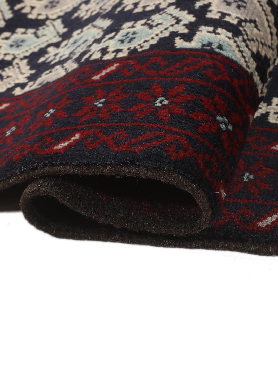 Handgeknoopt Baluch-tapijt met ingewikkelde geometrische motieven in donkerblauw en rood.