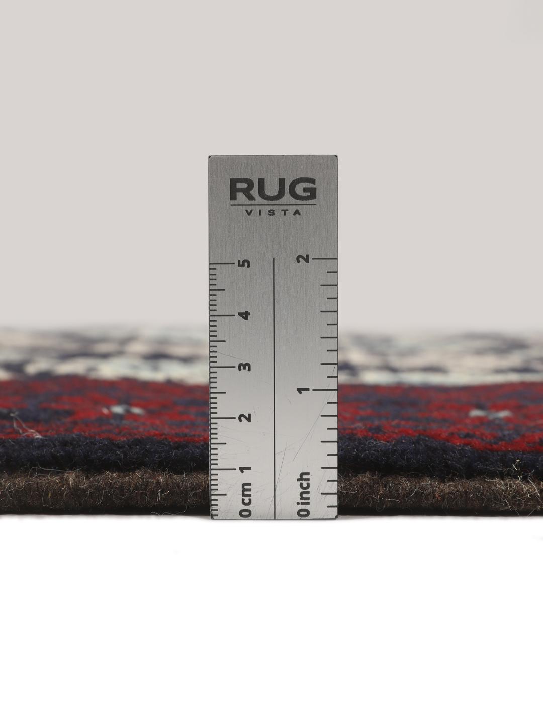 Handgeknoopt Baluch-tapijt met ingewikkelde geometrische motieven in donkerblauw en rood.