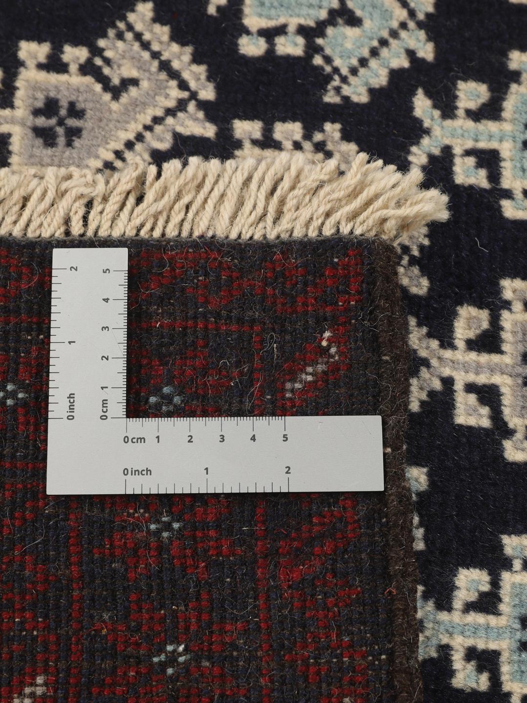 Handgeknoopt Baluch-tapijt met ingewikkelde geometrische motieven in donkerblauw en rood.
