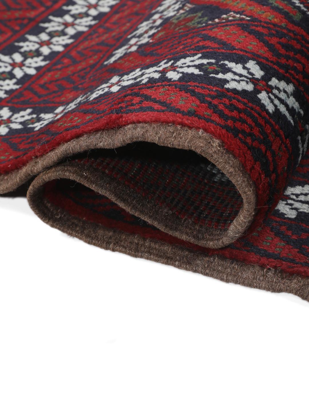 A hand-knotted Baluch rug from the Middle East featuring a dark-red and black geometric pattern.