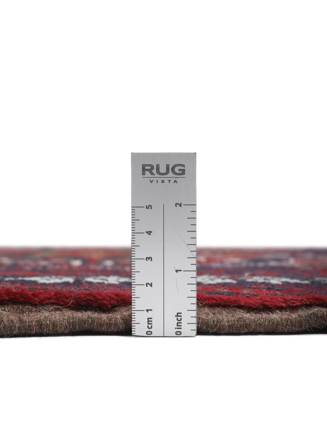 A hand-knotted Baluch rug from the Middle East featuring a dark-red and black geometric pattern.