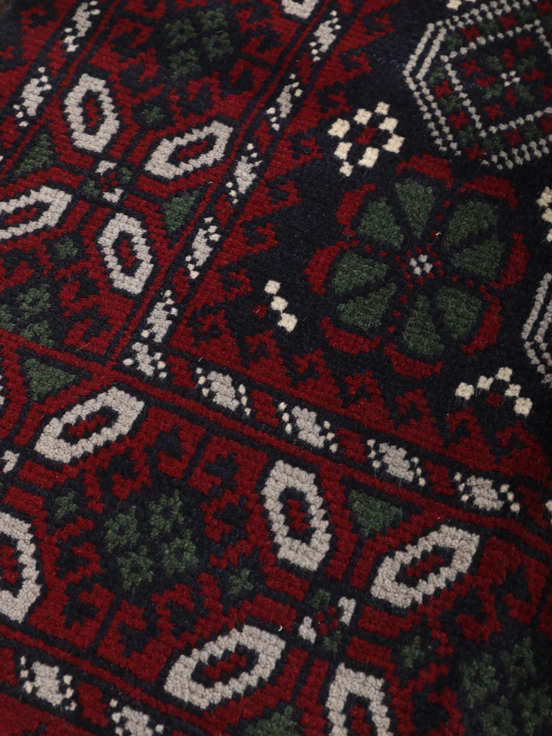 Handmade Baluch rug from the Middle East in dark blue and red tones.