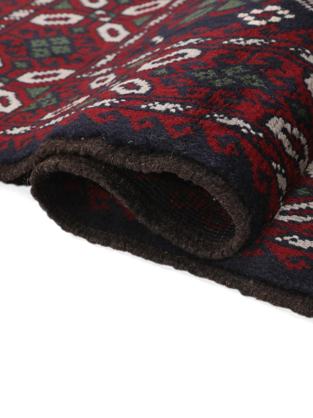 Handmade Baluch rug from the Middle East in dark blue and red tones.