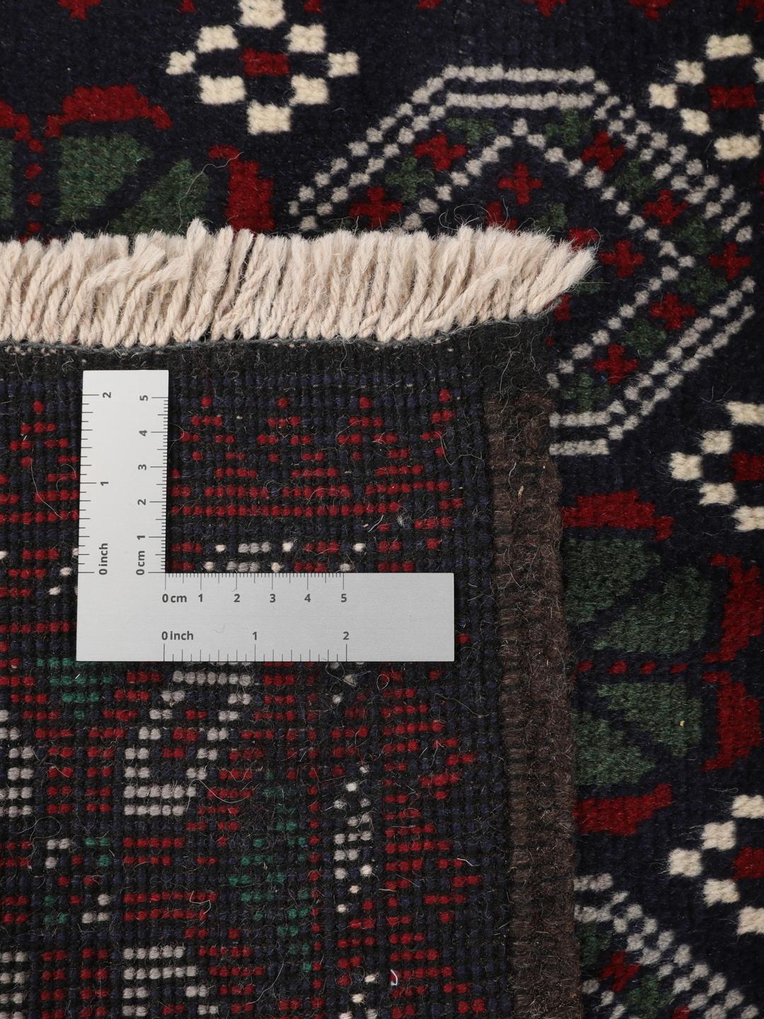 Handmade Baluch rug from the Middle East in dark blue and red tones.