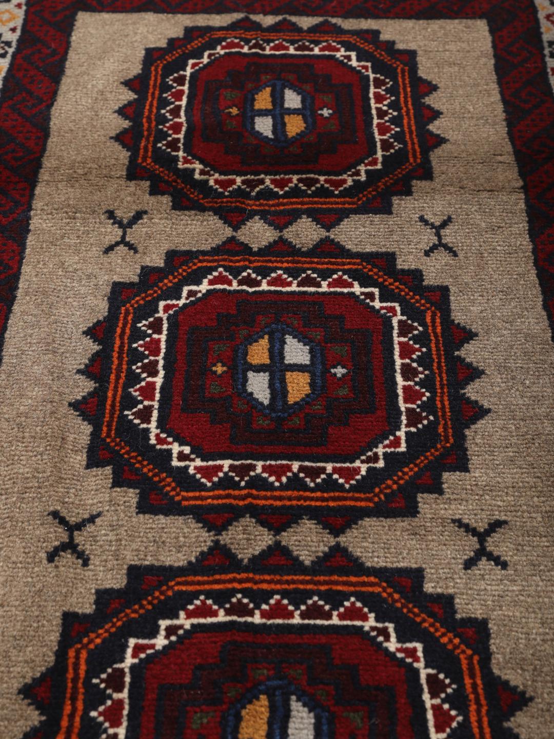 Hand-knotted Middle Eastern Baluch rug in red and beige tones