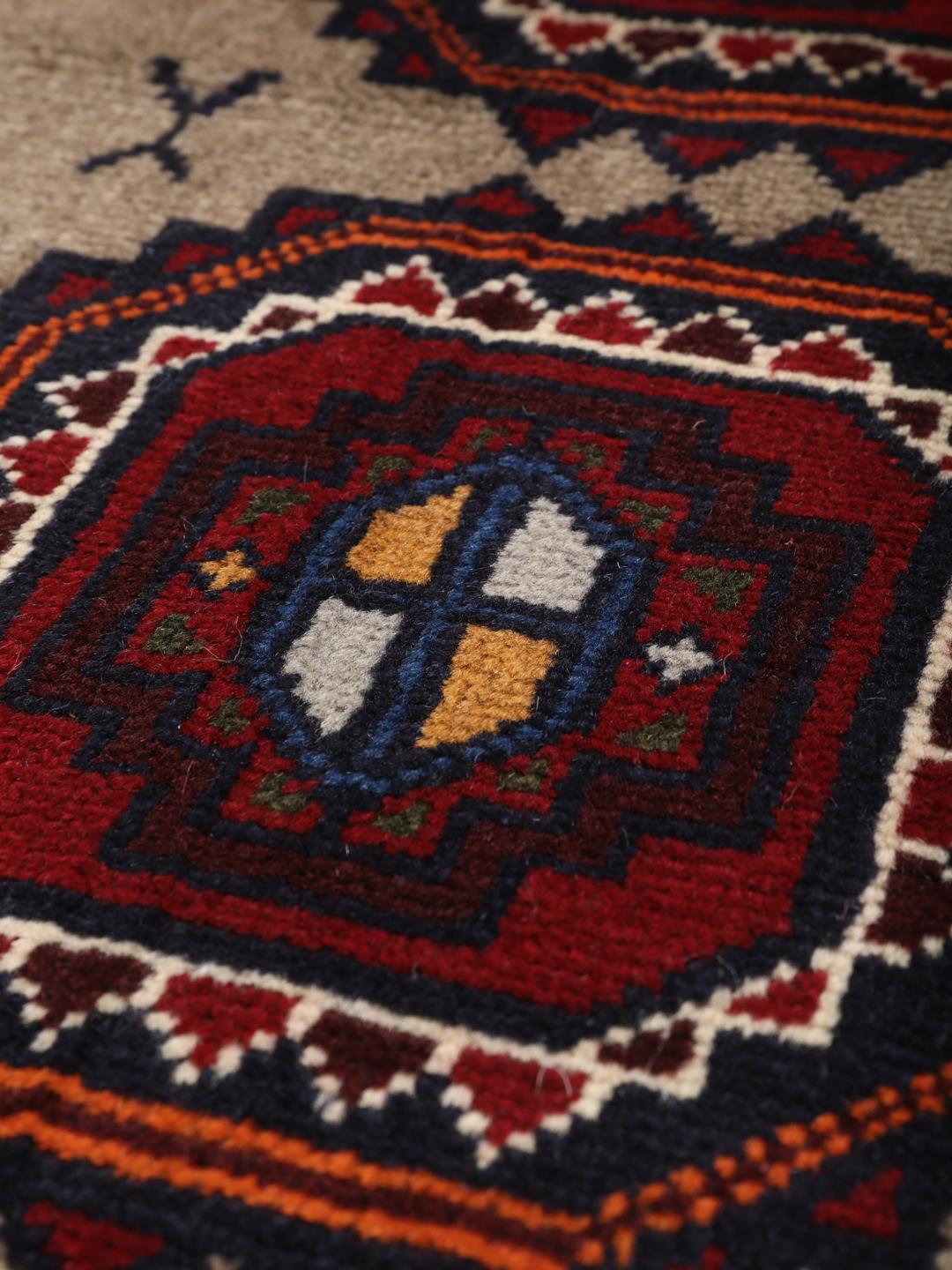 Hand-knotted Middle Eastern Baluch rug in red and beige tones