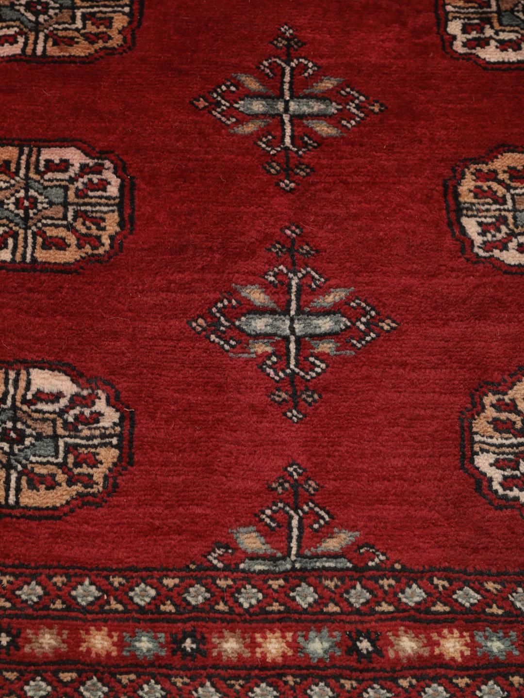 Handgeknoopt Pakistan Bokhara tapijt met een dieprood veld en traditionele herhalende motieven