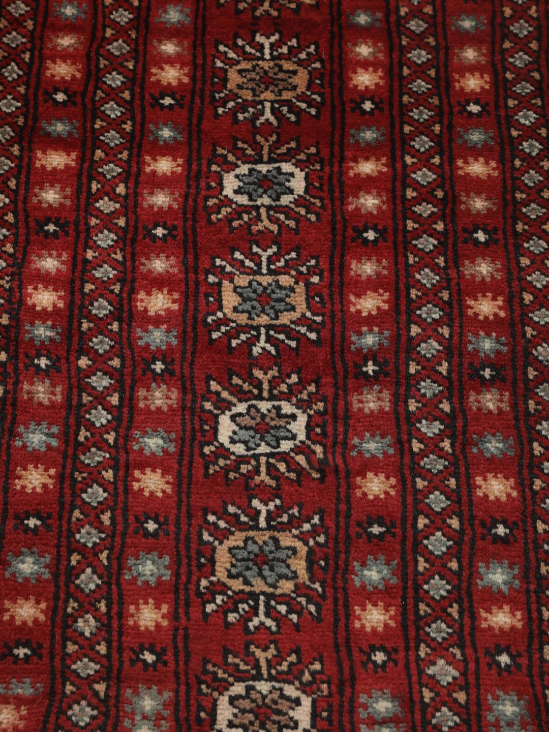 Handgeknoopt Pakistan Bokhara tapijt met een dieprood veld en traditionele herhalende motieven