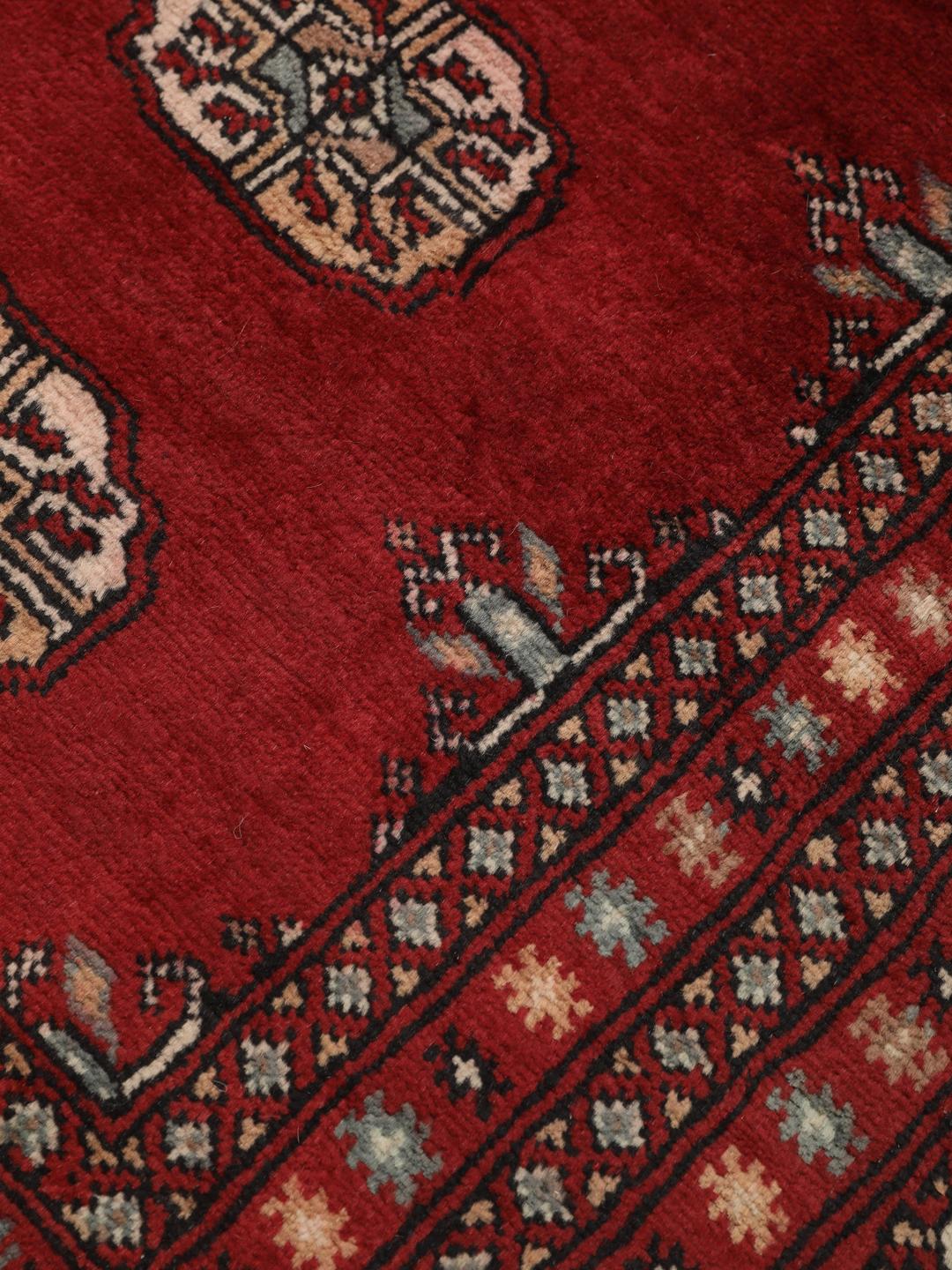 Handgeknoopt Pakistan Bokhara tapijt met een dieprood veld en traditionele herhalende motieven