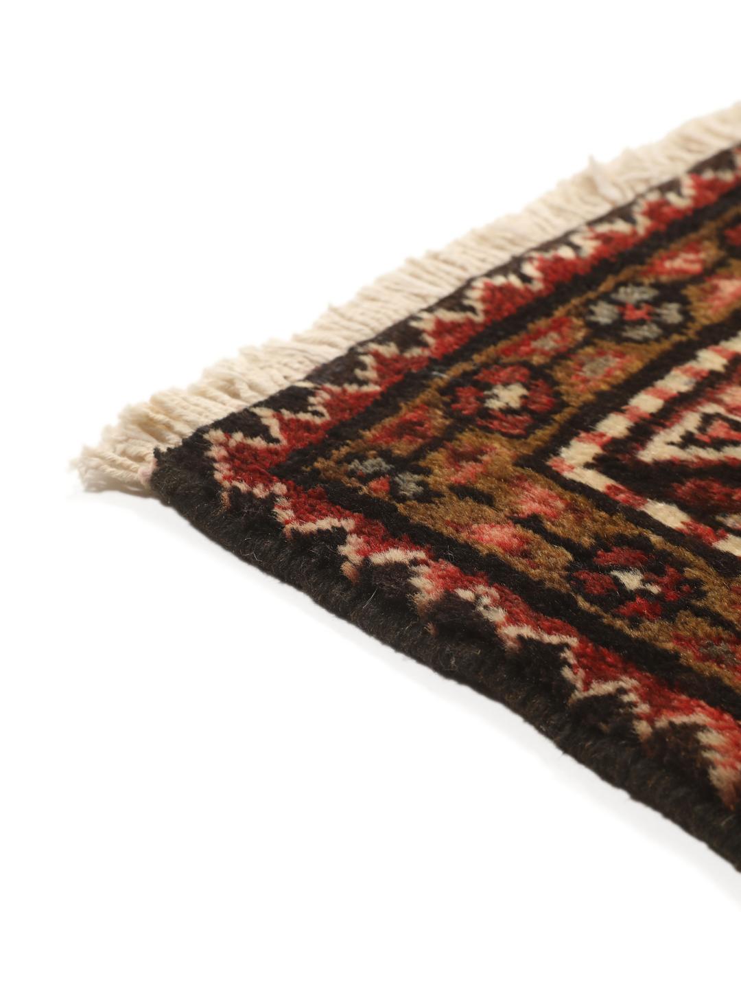 Een handgeknoopt donkerrood Hosseinabad-tapijt met ingewikkelde geometrische patronen.